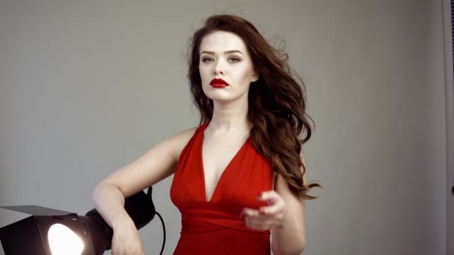 Schönes-Model-posiert-in-roten-Kleid-im-Fotostudio.