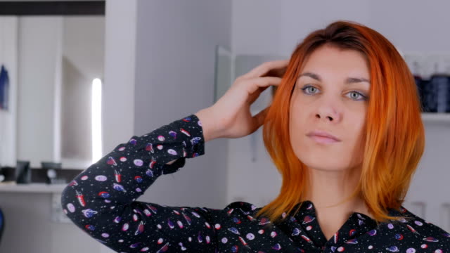 Hübsche-junge-Frau-mit-orange-Haarfarbe-im-Friseursalon