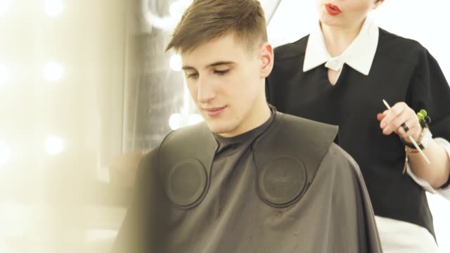Haircutter-rasieren-während-männliche-Coiff-Friseur-Haar.-Friseur-machen-professionelle-Frisur-mit-Rasierer-im-Beauty-studio