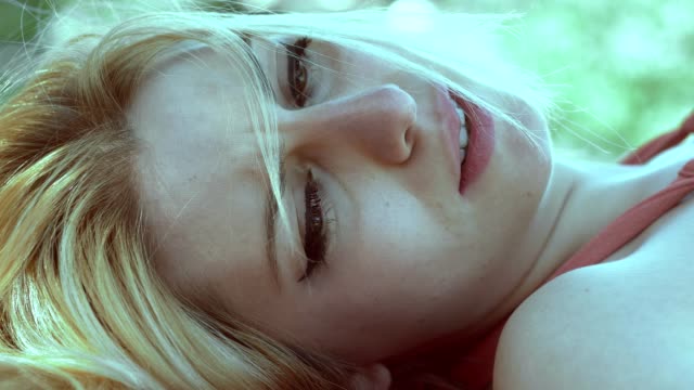 Tearful-sad-blonde-woman-lying-in-the-park.close-up