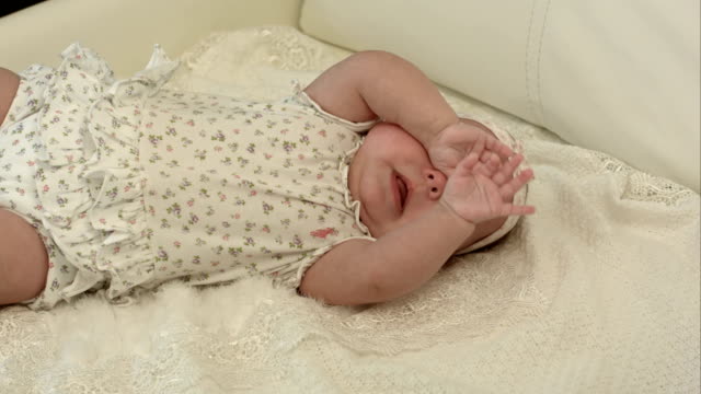 Baby-weint-auf-dem-Bett