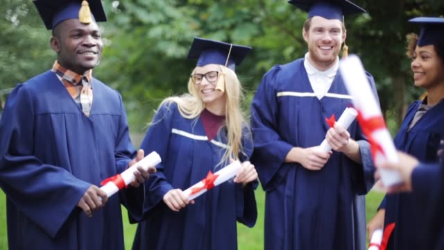 happy-students-in-mortar-boards-with-diplomas