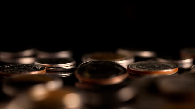 Close-up-slow-motion-Thai-Baht--money-coin-falling-to-the-floor-in-dark-light-,-business-and-financial-for-money-saving-or-investment-background-concept-with-black-copy-space-,-extremely-close-up-and-shallow-DOF