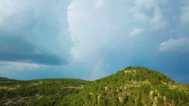 Regenbogen-hinter-Hügeln