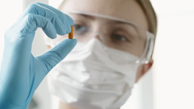 Mujer-científico-examinando-nueva-píldora