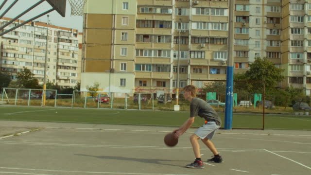 Basketball-Spieler-dribbeln-den-Ball-zwischen-den-Beinen