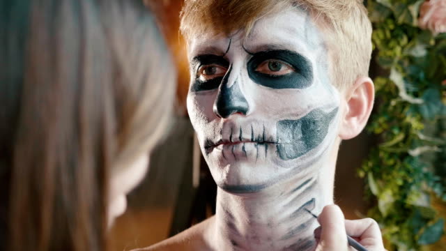 Make-up-artist-makes-the-guy-halloween-make-up.-Halloween-male-face-art.