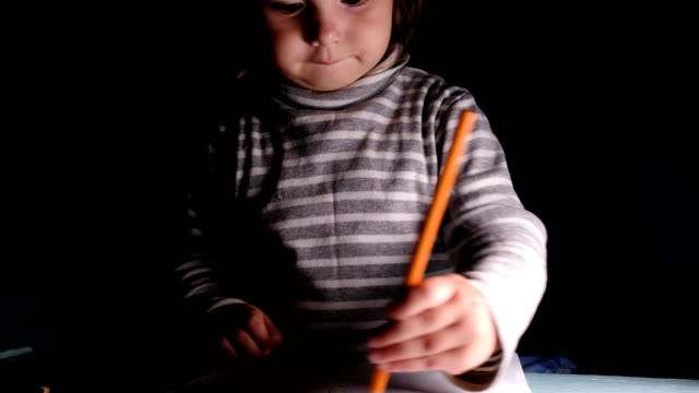 Baby-Girl-zieht-in-orange-Bleistift-und-Zeichnung-zeigt,-glücklich,-Nahaufnahme