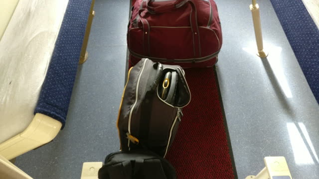 Dos-mochilas-y-un-bolso-en-una-cabina-del-compartimiento-vacío-para-cuatro-del-coche-durmiente