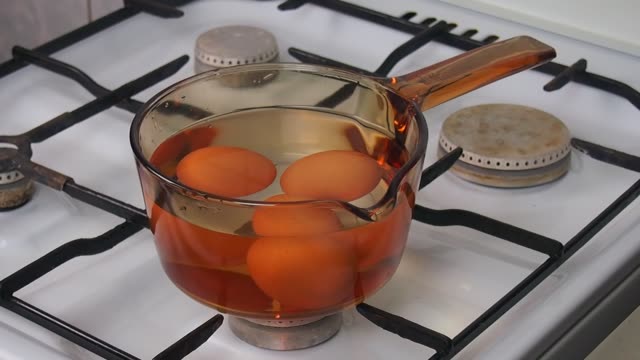 Set-fire-on-gas-stove-with-saucepan-with-eggs