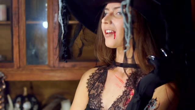 Halloween-witch-raises-her-head-from-under-the-hat-angrily-laughing