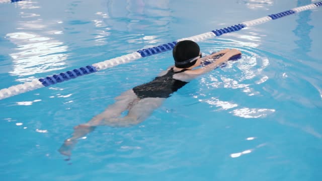 Schwimmkurse-für-Kinder-in-den-Pool---schönes-hellhäutige-Mädchen-im-Wasser-schwimmt