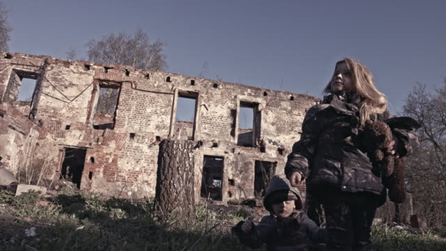 Hungrige-obdachlose-Kinder-in-der-Nähe-der-Ruinen.-Flüchtlinge
