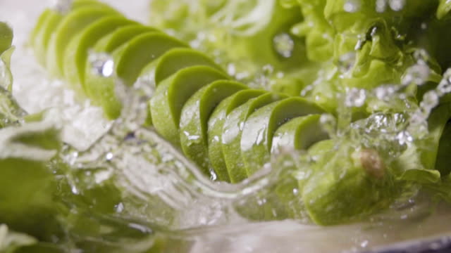 Falling-of-sliced-zucchini-into-the-wet-table.-Slow-motion-480-fps