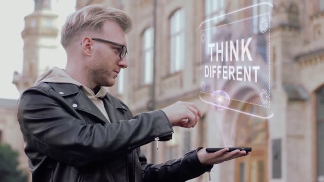 Kluger-junger-Mann-mit-Brille-zeigt-eine-konzeptionelle-Hologramm-denken-anders