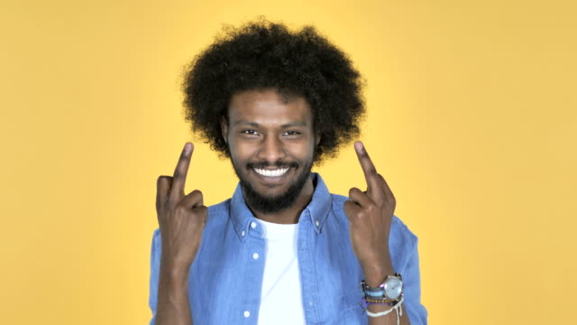 Afro-amerikanischer-Mann-zeigt-Mittelfinger-auf-gelbem-Hintergrund