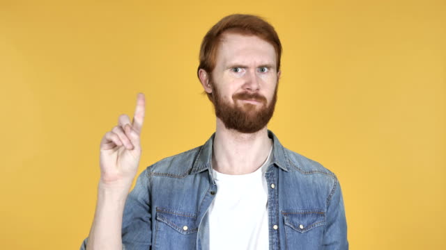 Redhead-hombre-agitando-el-dedo-para-rechazar-aislado-sobre-fondo-amarillo