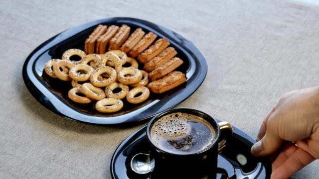Put-a-cup-of-coffee-on-the-table.-There-is-a-plate-with-homemade-cookies-on-the-table.