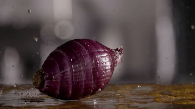 Falling-of-sliced-red-onion-into-the-wet-table.-Slow-motion-240-fps