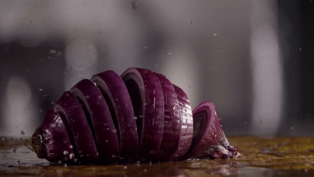 Falling-of-sliced-red-onion-into-the-wet-table.-Slow-motion-240-fps