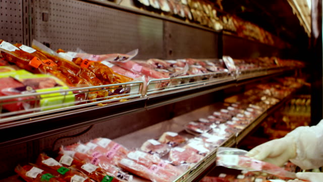 Butcher-arranging-wrapped-meat-in-rack-4k