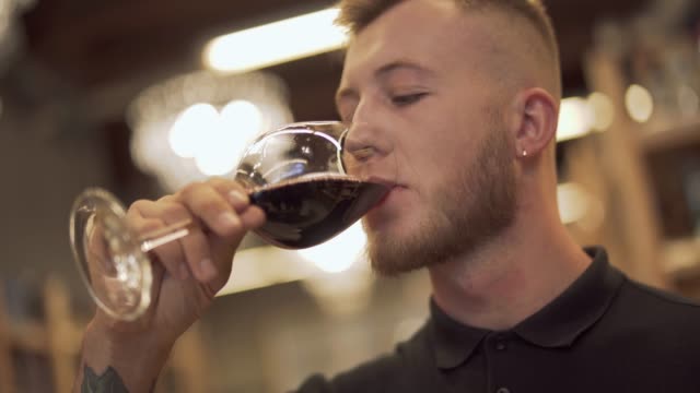 Portrait-of-handsome-male-drinking-wine-in-the-liquor-store.-Man-enjoys-wine-glass.