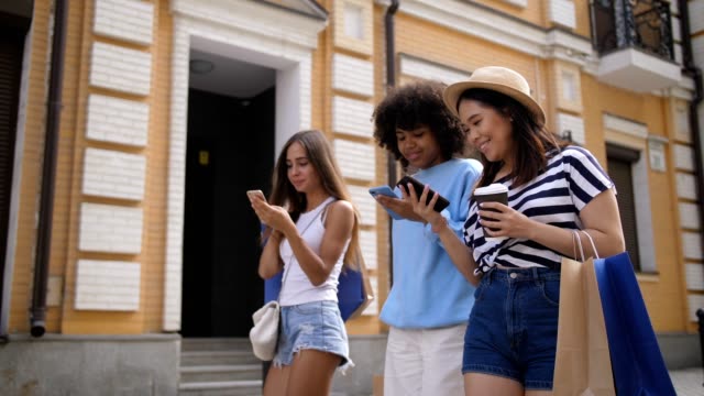 Diverse-girls-networking-with-cellphones-on-street