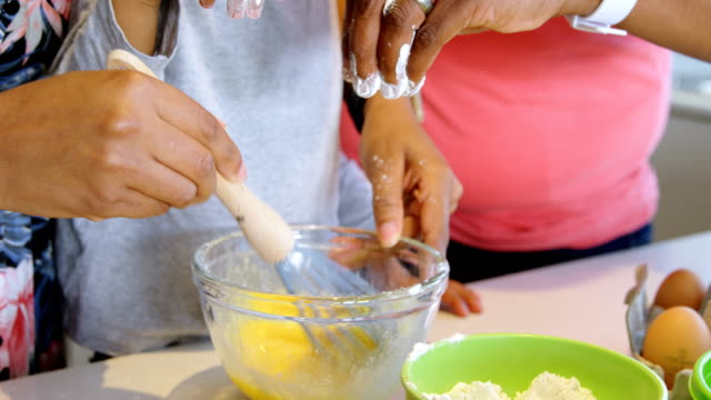 Father-and-son-pouring-flour-into-bowl-and-mother-whisking-eggs-4k