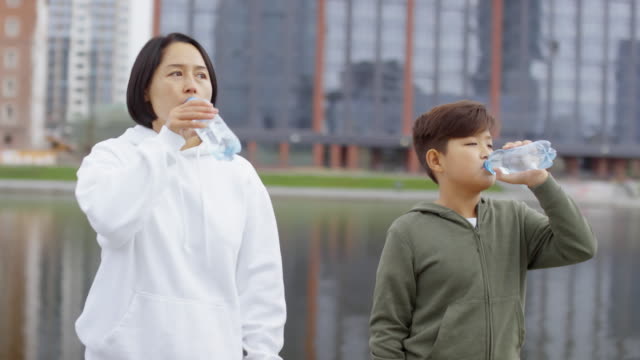 Asian-Mother-and-Son-Drinking-Water-after-Morning-Run