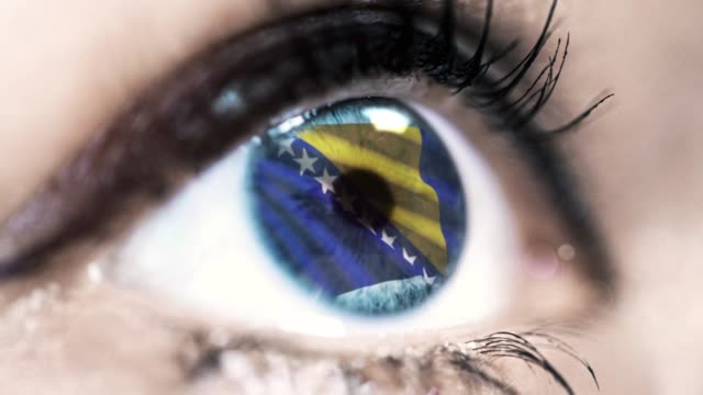 mujer-ojo-azul-en-primer-plano-con-la-bandera-de-Bosnia-y-Herzegovina-en-el-iris-con-el-movimiento-del-viento.-concepto-de-vídeo
