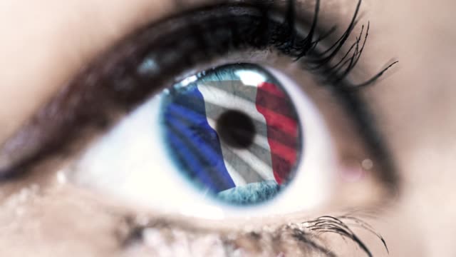 Frau-blaues-Auge-in-Nahaufnahme-mit-der-Flagge-von-Frankreich-in-Iris-mit-Windbewegung.-Videokonzept