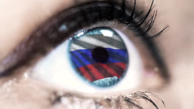 Frau-blaues-Auge-in-Nahaufnahme-mit-der-Flagge-von-Russland-in-Iris-mit-Windbewegung.-Videokonzept