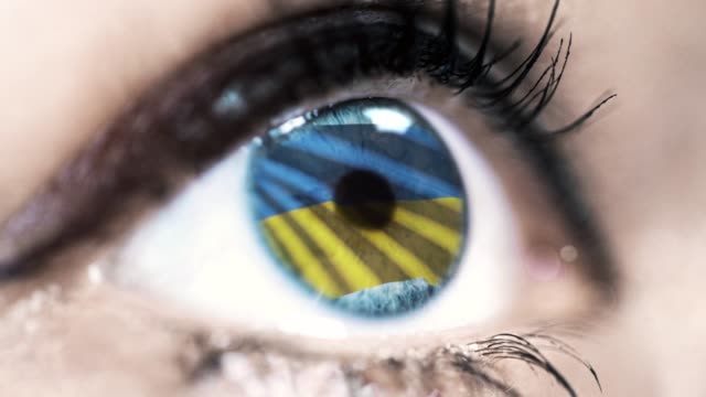 woman-blue-eye-in-close-up-with-the-flag-of-ukraine-in-iris-with-wind-motion.-video-concept