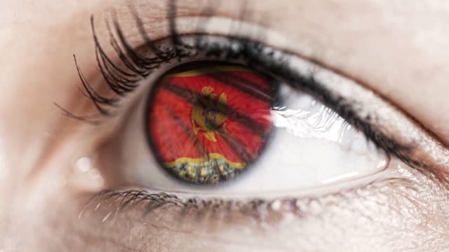 Frau-grünes-Auge-in-Nahaufnahme-mit-der-Flagge-von-Montenegro-in-Iris-mit-Windbewegung.-Videokonzept