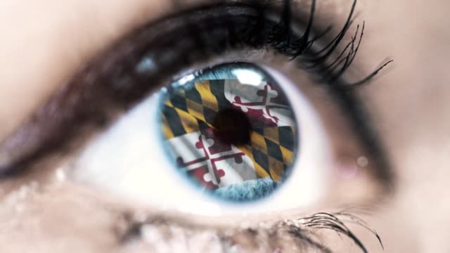 Frau-blaues-Auge-in-Nahaufnahme-mit-der-Flagge-von-Maryland-Staat-in-Iris,-vereinigte-Staaten-von-Amerika-mit-Windbewegung.-Videokonzept