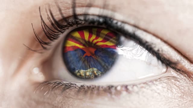 Mujer-ojo-verde-en-primer-plano-con-la-bandera-del-estado-de-Arizona-en-iris,-estados-unidos-de-América-con-movimiento-de-viento.-concepto-de-vídeo