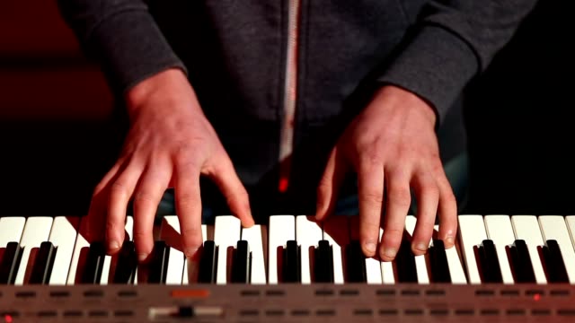 Mannhände-elektronisches-Keyboard-auf-der-Bühne-zu-spielen