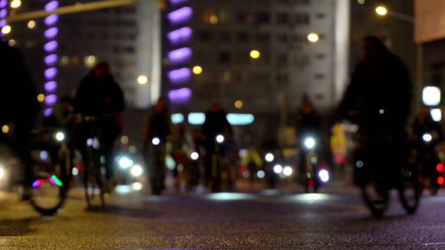 Mucho-paseo-de-ciclistas-en-bicicleta-bicicleta-de-noche,-desfile-de-bicicletas-en-desenfoque-de-timelapse-calle-de-ciudad-de-noche-iluminada.-Multitud-de-gente-en-bicicleta.-Tráfico-de-bicicleta.-Estilo-de-vida-saludable-concepto-de-deporte.-Luces-brillantes.-Vista-de-ángulo-bajo