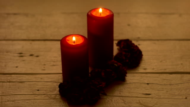 Red-candles-light-with-rose-on-white-wooden-desk