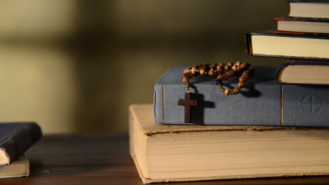 Bible-With-Books-And-Rosary,-zoom-in