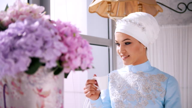 Hermosa-modelo-musulmana-en-vestido-de-boda-azul-tomando-café