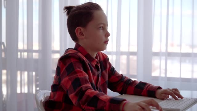 Boy-using-computer-at-home-and-receive-call-on-smartphone.-Emotions