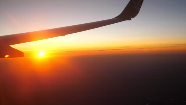 Blick-vom-Flugzeugfenster-zu-schönen-Sonnenaufgang-oder-Sonnenuntergang.-Flügel-des-Flugzeugs-und-Wolke-Himmel.-Konzept-der-Reisen-oder-Tourismus.-Nahaufnahme-Seitenansicht