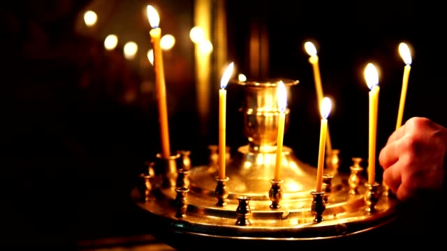 Man-corrects-burning-candles-in-the-candlestick-in-the-Orthodox-Church