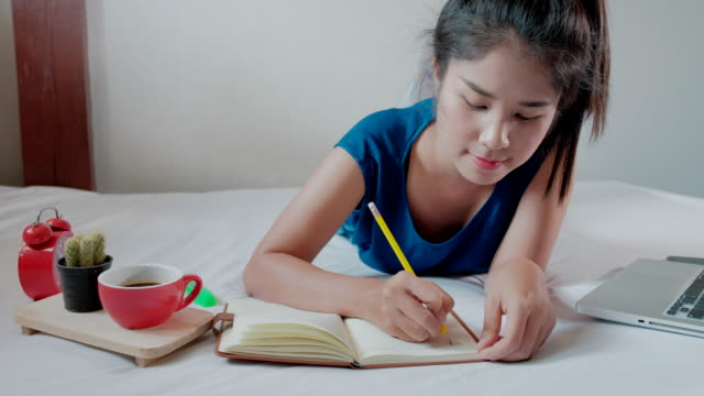 Frau-Hand-mit-Stift-schreiben-Notebook-auf-bedroom.4k-Footage