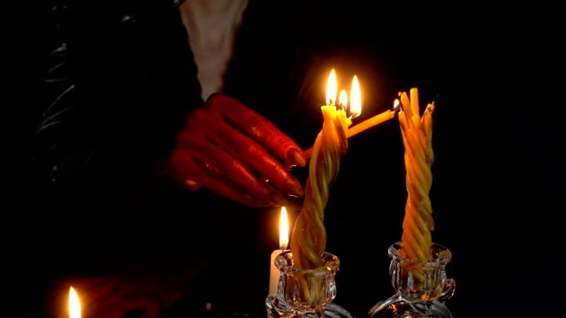 Woman-with-blood-hands-lights-candles