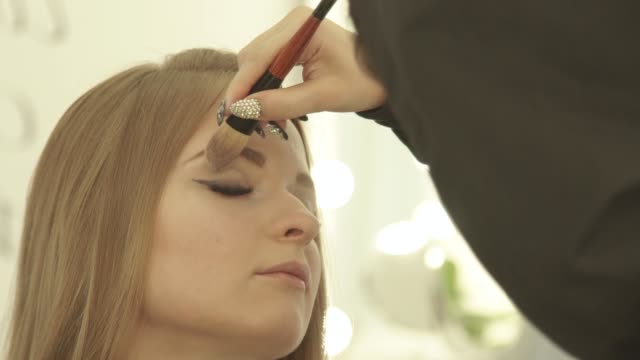 Künstler-mit-Kosmetik-Pinsel-für-Make-up-Augen-im-Beauty-Studio-machen.-Nahaufnahme-der-Visagist-Make-up-für-Mädchen-Mode-Modell-zu-tun