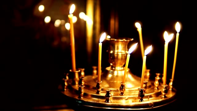 Burning-candles-in-front-of-the-Orthodox-icon-slow-motion