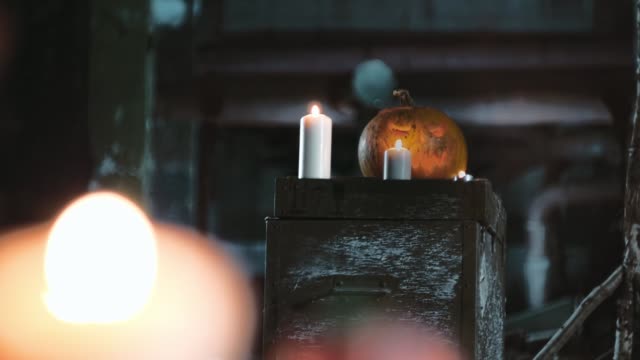 Geschnitzte-Halloween-Kürbis-und-Kerzen-auf-einem-alten-Vintage-Box-in-ein-Candle-light-in-verlassenen-Fabrik.-Geringe-Schärfentiefe.-Bokeh-Hintergrund