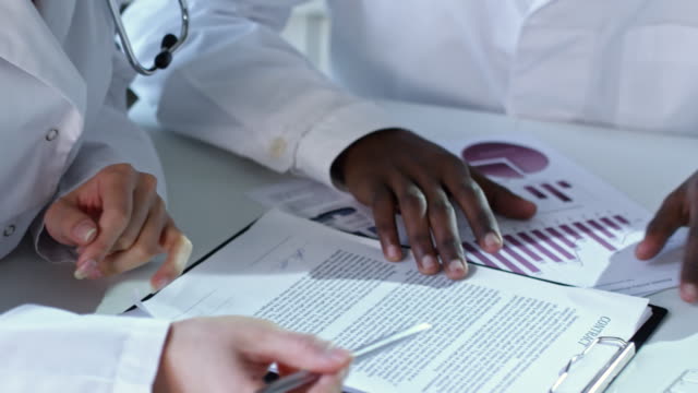 Multi-étnica-médicos-discutiendo-los-documentos